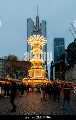 Eine vertikale Aufnahme einer Weihnachtspyramide auf dem „Rossmarkt“-Weihnachtsmarkt am Abend in Frankfurt Stockfoto