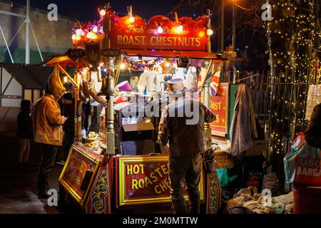 Der jährliche Lincoln Christmas Market findet jedes erste Wochenende im Dezember statt. Der Markt findet in der bergauf gelegenen Gegend der Stadt statt, bekannt als Bailgate, hauptsächlich um die Kathedrale und das Schloss herum. Die Kathedrale, wenn sie mit Flutlicht beleuchtet wurde, im Jahr 2022 eine blaue/violette Farbe, was sie zu einem zentralen Stück macht, das über der Stadt zu sehen ist. Tausende von Menschen aus ganz Europa auf den Markt zu bringen, wird manchmal zu einem Einbahnsystem, das es der großen Zahl von Menschen ermöglicht, sicher umherzugehen. Er hat gebratene Kastanien in der Nähe des Schlossgeländes verkauft Stockfoto