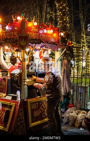 Der jährliche Lincoln Christmas Market findet jedes erste Wochenende im Dezember statt. Der Markt findet in der bergauf gelegenen Gegend der Stadt statt, bekannt als Bailgate, hauptsächlich um die Kathedrale und das Schloss herum. Die Kathedrale, wenn sie mit Flutlicht beleuchtet wurde, im Jahr 2022 eine blaue/violette Farbe, was sie zu einem zentralen Stück macht, das über der Stadt zu sehen ist. Tausende von Menschen aus ganz Europa auf den Markt zu bringen, wird manchmal zu einem Einbahnsystem, das es der großen Zahl von Menschen ermöglicht, sicher umherzugehen. Er hat gebratene Kastanien in der Nähe des Schlossgeländes verkauft Stockfoto