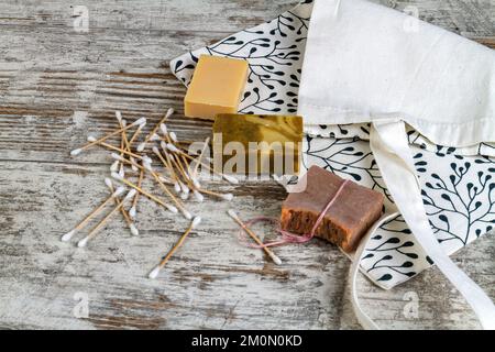 Viele Ohrstöpsel und Seifen auf grauem Holzschreibtisch. Sachen für Spa. Stockfoto