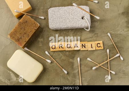 Ansicht von oben organisches Badzubehör auf braunem Hintergrund. Handgefertigte Seifen mit Ohrstöpseln. Stockfoto