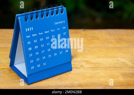 Januar 2023 blauer Tischkalender auf Holztisch mit anpassbarem Platz für Text. Stockfoto