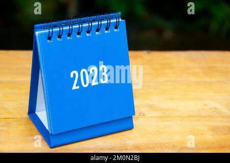 2023 blauer Tischkalender auf Holztisch. Neujahrskonzept. Stockfoto