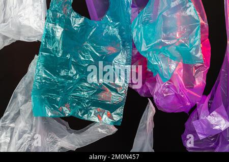 Sammlung verschiedener auf schwarzem Hintergrund isolierter Kunststoffbeutel. Plastisches Verschmutzungskonzept. Stockfoto