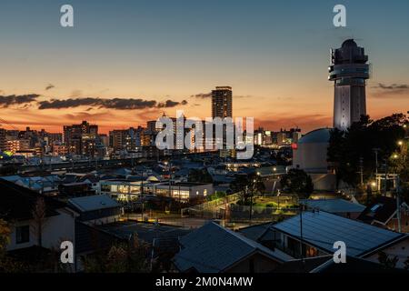 Nach Sonnenuntergang glüht hinter dem Uhrturm von Akashi und der Stadt am frühen Abend Stockfoto