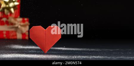 Banner für Valentinstag, rotes Papierherz und Geschenke auf schwarzem Hintergrund, Origami, Platz für Text. Stockfoto