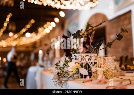 Tischeinstellung für Hochzeitsfeier Dekor Blumen Lichter verschwommen Hintergrund Stockfoto