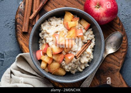 Haferbrei mit Apfel und Zimt in der Schüssel, Draufsicht. Gesundes Frühstück Stockfoto