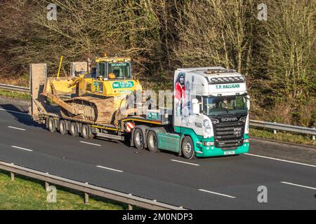 T.P. HALLIGAN SCANIA SUPER STGO CAT2 LKW und Tieflader mit INSGESAMT GEMIETETEM KOMATSU Hydraulikbagger auf der Autobahn M61 UK. Stockfoto