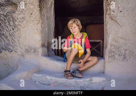 Junge Touristen, die das Tal mit Felsformationen und Feenhöhlen in der Nähe von Goreme in Kappadokien, Türkei, erkunden Stockfoto