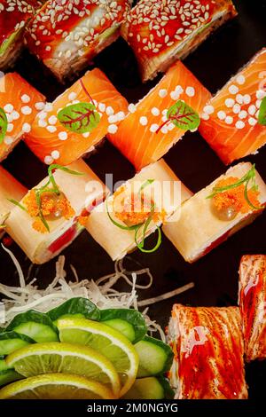 Set Sushi-Brötchen mit Thunfisch, Lachs und Aal, verpackt in einem Karton Stockfoto
