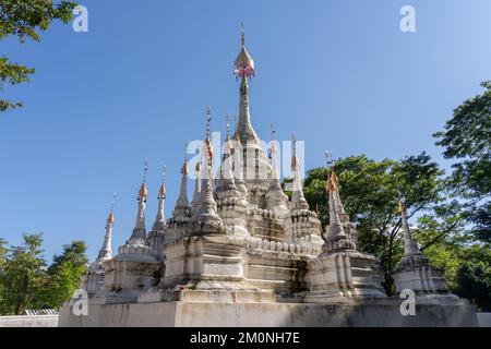 Blick auf den antiken weißen Stupa mit mehreren Türmen und goldenen Finalen vor dem buddhistischen Tempel Wat Tham Chiang Dao Höhle, Chiang Dao, Chiang Mai, Thailand Stockfoto