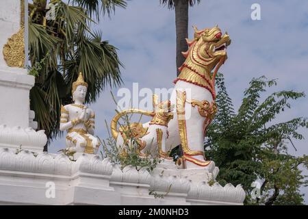 Weißer und goldener Löwe oder singha Schutzstatue, die an der Ecke der antiken Stupa steht, Wat Chiang Yuen buddhistischer Tempel, Chiang Mai, Thailand Stockfoto