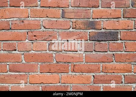 Detail mit alten roten Ziegeln in der Wand mit Zement und Narben des Alters Stockfoto
