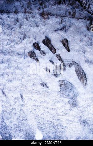 Handabdruck in gefrorenem Schnee und Eis auf einer Felsoberfläche Stockfoto