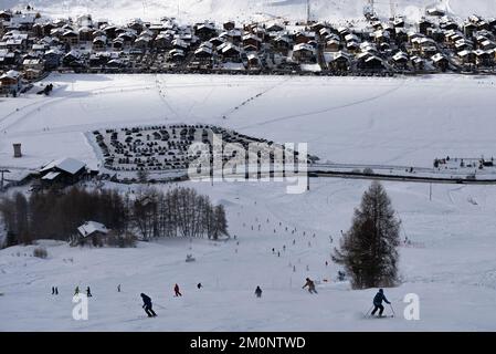 Leute, die den Hang hinunter mit Snowboarden fahren. Stadt Livigno im Winter. Livigno Landskapes in der Lombardei, Italien, in den italienischen Alpen, in der Nähe der Swis Stockfoto