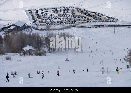 Leute, die den Hang hinunter mit Snowboarden fahren. Stadt Livigno im Winter. Livigno Landskapes in der Lombardei, Italien, in den italienischen Alpen, in der Nähe der Swis Stockfoto