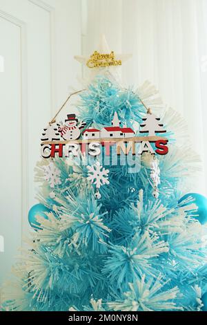 Wunderschöner hellblauer Weihnachtsbaum im weißen Zimmer Stockfoto