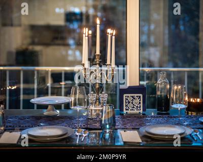 Kerzenleuchter und brennende Kerzen auf dem Serviertisch. Panoramafenster. Stockfoto