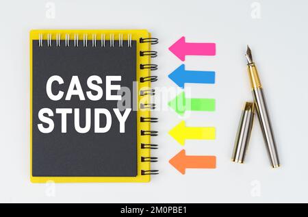 Geschäfts- und Finanzkonzept. Auf weißem Hintergrund liegen ein Stift, Pfeile und ein Notizbuch mit der Aufschrift – FALLSTUDIE Stockfoto