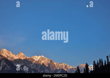 Sonamarg, Indien. 04.. Dezember 2022. An einem kalten Wintertag in Sonamarg, etwa 100kms km nordöstlich von Srinagar, der Sommerhauptstadt von Jammu und Kaschmir, erhebt sich der wachsende Gibbuus-Mond über den schneebedeckten Bergen. (Foto: Saqib Majeed/SOPA Images/Sipa USA) Guthaben: SIPA USA/Alamy Live News Stockfoto