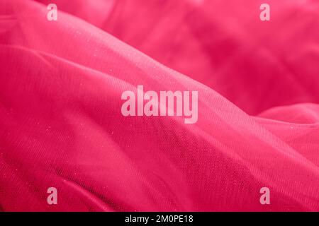 Roter Stoffhintergrund aus Organza, Tüll, Seide. Abstrakter Hintergrund mit Glitzer. viva Magenta Stockfoto