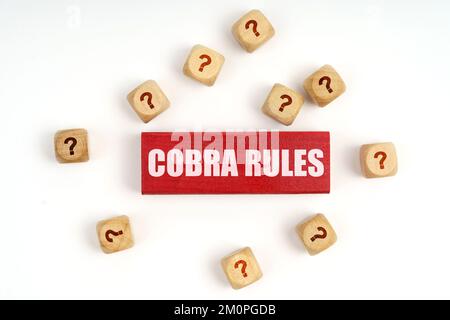 Fragekonzept. Auf dem Tisch befinden sich Würfel mit Fragen und eine rote Tafel mit der Aufschrift „Cobra Rules“ Stockfoto