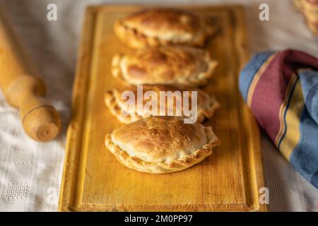 Argentinische Empanadas auf einem Brett gebacken. Stockfoto