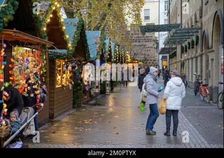 BONN, DEUTSCHLAND - 6. DEZEMBER 2022: Verkaufsstände mit einem Teil von Sterntor hinten Stockfoto