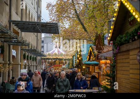 BONN, DEUTSCHLAND - 6. DEZEMBER 2022: Verkaufsstände mit historischem Karussell hinten Stockfoto