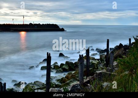 Langzeitbelichtungsfoto von einem Wellenbrecher, wo der Fluss auf den Ozean trifft. Stockfoto