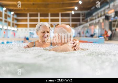 Innenporträt von zwei glücklichen weißen Großeltern, die sich in einem Bad entspannen und aktiv ihre Zeit verbringen. Muskelspannungsabbau. Hochwertiges Foto Stockfoto