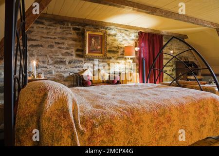 Doppelbett bedeckt mit Blumenmotiv Bettüberwurf im Hauptschlafzimmer im oberen Stockwerk in alten um 1850 Canadiana Cottage Stil Feldsteinhaus. Stockfoto