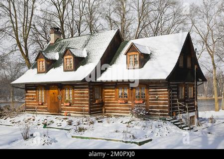 1980 erbaute Nachbildung des alten 1800er zweistöckigen Canadiana Cottage-Blockhauses im Winter. Stockfoto