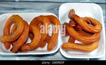 Türkische Churros, sehr beliebte Street Food oder Street Desserts in der Türkei, kreisförmiges Chalka Tatlisi Dessert in Öl gebraten und mit Honigsirup gesüßt, s Stockfoto