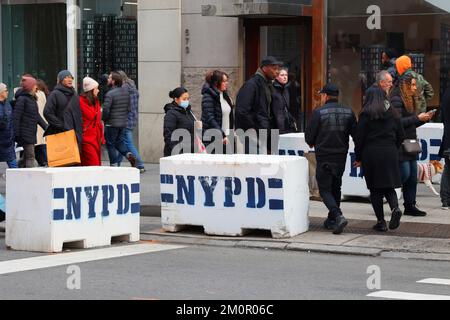 Menschen, die während des Open Streets Sunday auf der Fifth Ave, New York, am 4. Dezember 2022 durch eine Betonbarriere des NYPD laufen, um Lkw-Angriffe abzuwehren. Stockfoto