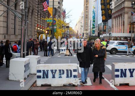 Menschen, die während des Open Streets Sunday auf der Fifth Ave, New York, am 4. Dezember 2022 durch eine Betonbarriere des NYPD laufen, um Lkw-Angriffe abzuwehren. Stockfoto