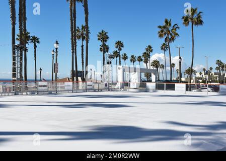HUNTINGTON BEACH, KALIFORNIEN - 7. DEZ. 2022: Saisonale Eislaufbahn am Huntington Beach Pier Plaza. Stockfoto