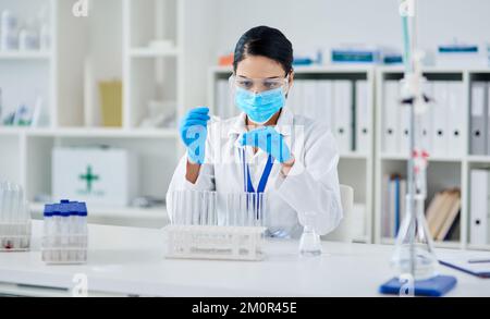 Die Zukunft eines Experiments nach dem anderen ändern. Ein junger Wissenschaftler, der ein Experiment in einem Labor durchführt. Stockfoto
