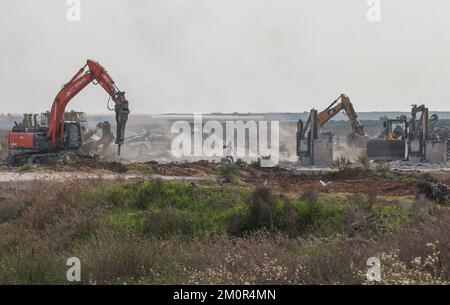 Gaza, Palästina. 07.. Dezember 2022. Israelische Arbeiter arbeiten in der Nähe der Grenze zu Gaza, während Bulldozer und Kräne Karni an der Handelsübergangsstelle auf der Ostseite von Gaza-Stadt demontieren, da Israel beschloss, eine Sicherheitsbarriere am Standort des seit langem stillgelegten Terminals zu erweitern. Kredit: SOPA Images Limited/Alamy Live News Stockfoto