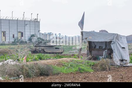 Gaza, Palästina. 07.. Dezember 2022. In der Nähe israelischer Bagger und Bulldozer ist ein israelischer Merkava-Kampfpanzer stationiert, der die Überreste des Karni-Handelsübergangs in der Nähe der Grenze zu Gaza abriss, als Israel beschloss, eine Sicherheitsbarriere am Standort des seit langem stillgelegten Terminals zu erweitern. Kredit: SOPA Images Limited/Alamy Live News Stockfoto