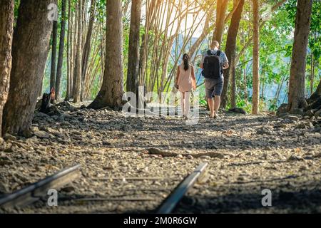 Rückansicht des männlichen Touristen und seiner Tochter, die zusammen im Wald wandern Naturpfad Wanderung auf Trail Wald Hintergrund am Hellfire Pass in Kanchanaburi Thai Stockfoto