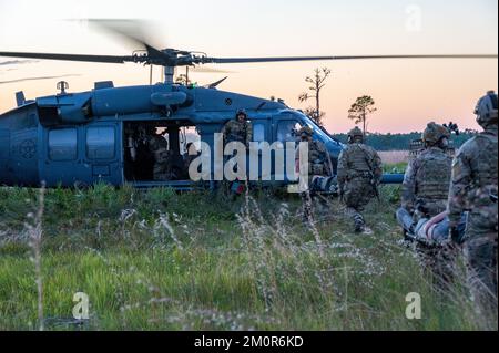 920. Rettungsflügelflugzeuge tragen Patienten, die Verletzungen eines HH-60G Pave Hawk Hubschraubers im Avon Park Air Force Range, Florida, simulieren, 18. November 2022. Flugzeuge aus der anderen Seite des Flügels haben dafür gearbeitet, dass Sanitäter und Flugpersonal von HH-60G Pave Hawk und HC-130J Combat King II Flugzeugen ihre Fähigkeiten zur Behandlung schwer verletzter Patienten an knappen Orten, zur Unterstützung von Spezialeinsatzteams am Boden und zur Durchführung längerer Landbewegungen und Patientenversorgung während des Fluges verbesserten. (USA Air Force Foto von Master Sgt. Kelly Goonan) Stockfoto