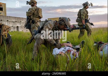 920. Rettungsflügel-Sanitäter versorgen Patienten unter dem Vorbild von Verletzungen am Avon Park Air Force Range, Florida, 18. November 2022. Flugzeuge aus der anderen Seite des Flügels haben dafür gearbeitet, dass Sanitäter und Flugpersonal von HH-60G Pave Hawk und HC-130J Combat King II Flugzeugen ihre Fähigkeiten zur Behandlung schwer verletzter Patienten an knappen Orten, zur Unterstützung von Spezialeinsatzteams am Boden und zur Durchführung längerer Landbewegungen und Patientenversorgung während des Fluges verbesserten. (USA Air Force Foto von Master Sgt. Kelly Goonan) Stockfoto