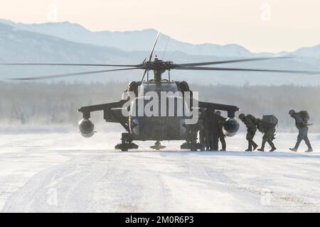 Die ROTC-Kadetten der University of Alaska Army gehen an Bord eines Alaska Army National Guard UH-60L Black Hawk Helikopters, der dem 1-207. Aviation Regiment zugeteilt wurde, während einer Flugübungsveranstaltung auf der Joint Base Elmendorf-Richardson, Alaska, 2. Dezember 2022. Nach der taktischen Insertion manövrierten die Seawolf-Truppenkadetten über schneebedecktes Gelände, griffen Oppositionstruppen an, sicherten sich ihr Ziel und beendeten sie mit einer Luftextraktion. Das General Support Aviation Battalion der AKARNG bildet routinemäßig mit allen Zweigen des Militärs sowie mit zivilen Organisationen zusammen, um seine operative Verbindung zu verbessern Stockfoto