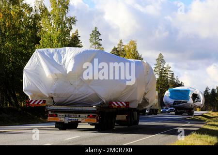 Der Konvoi zweier schwerer Lastkraftwagen, die Planen transportieren, hat große Lasten auf der Autobahn transportiert. Rückansicht. Raasepori, Finnland. 23. September 2022 Stockfoto