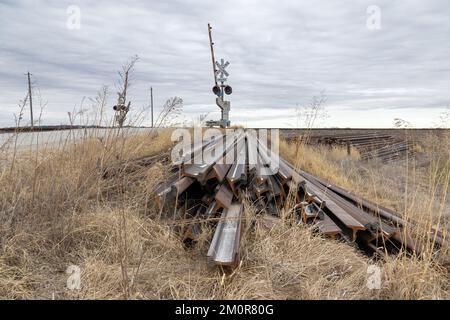 Ein Haufen verrosteter Schienen am Straßenrand neben einer BNSF-Eisenbahnstrecke im ländlichen Lee County, Iowa Stockfoto