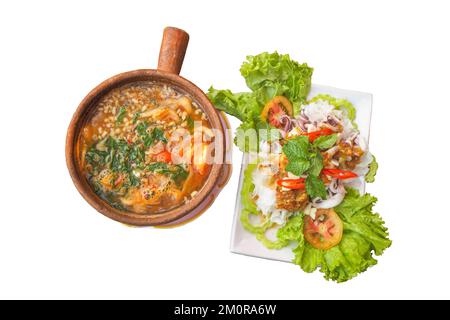 Tisch mit thailändischen Gerichten wie Curry, Eier, gedünsteter Tintenfisch, Zitrone. Stockfoto