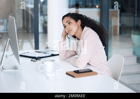 Müder junger Callcenter-Agent aus gemischten Rassen, der einen Desktop-Computer benutzt, ein Headset trägt und Anrufe entgegennimmt. Unzufriedene Kundendienstmitarbeiterin Stockfoto