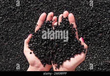 Schwarzer Sand in deinen Händen. Schwarzer Strand von Lanzarote Stockfoto